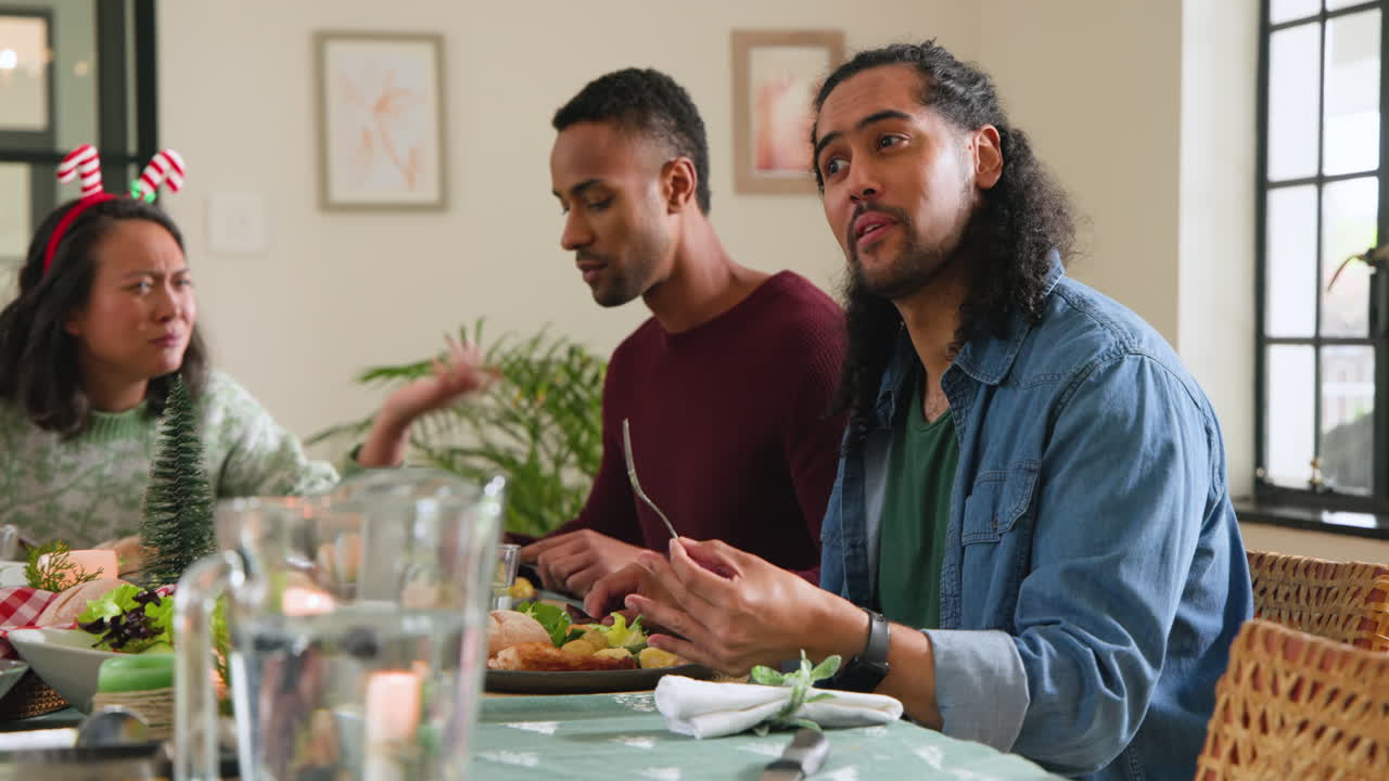 At christmas, sharing stories and laughter, diverse friends having festive meal together at holiday
