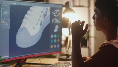 person designing shoes on computer