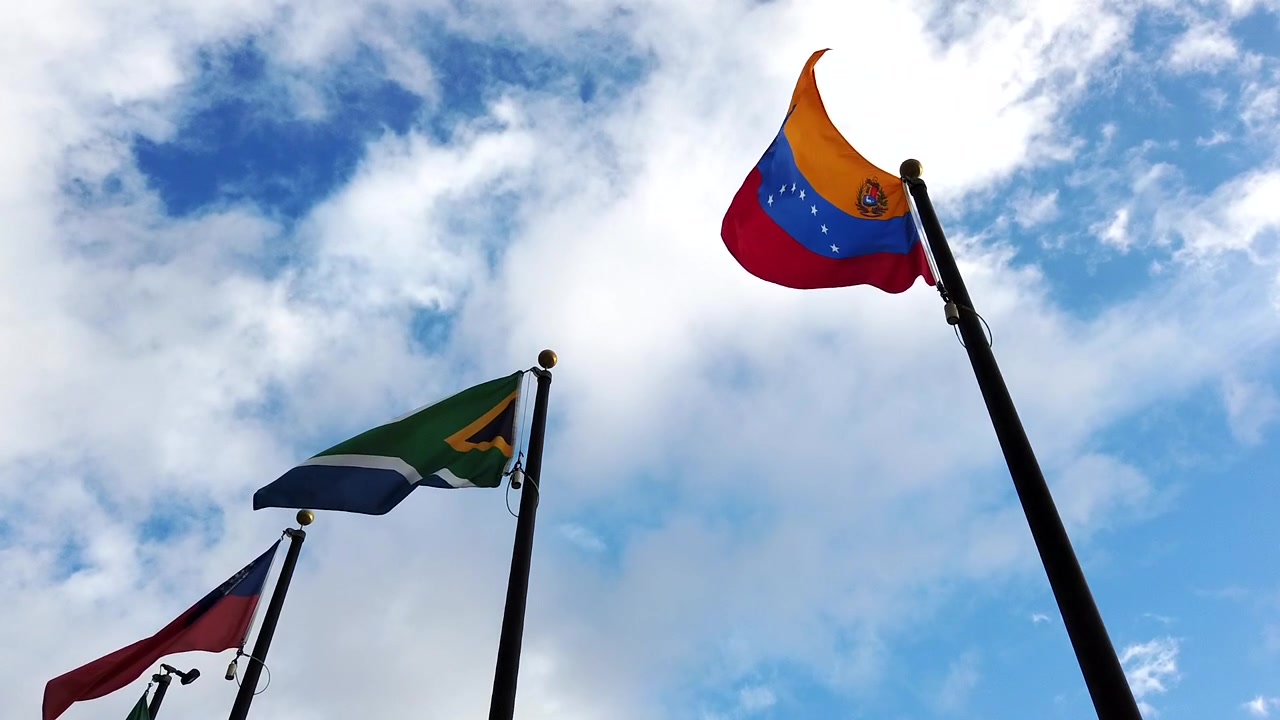 Bandera de Sudáfrica, bandera de la Unión de Birmania y bandera de Venezuela ondeando con una brisa ligera.