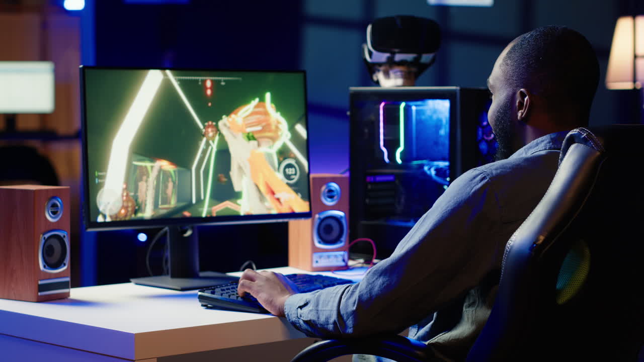 Man having fun by playing videogames on gaming PC at computer desk