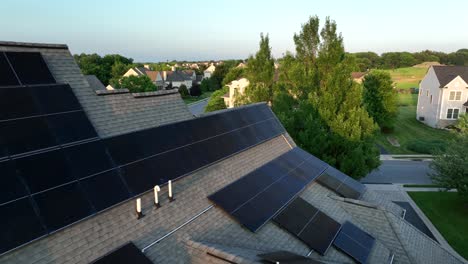 single family house with modern solar panels on roof at golden sunset. aerial view. quiet evening in small neighborhood of kansas, usa