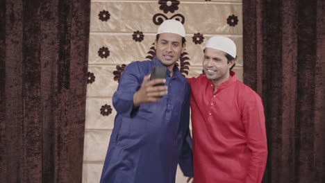 two muslim men clicking selfie photos