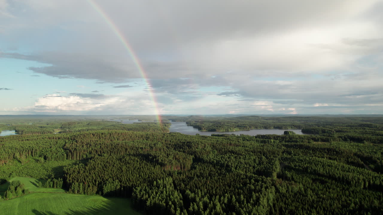impresionante arco iris sobre hermoso bosque sereno y paisaje de lagos en finlandia, cerca de kuopio, cámara volando hacia abajo