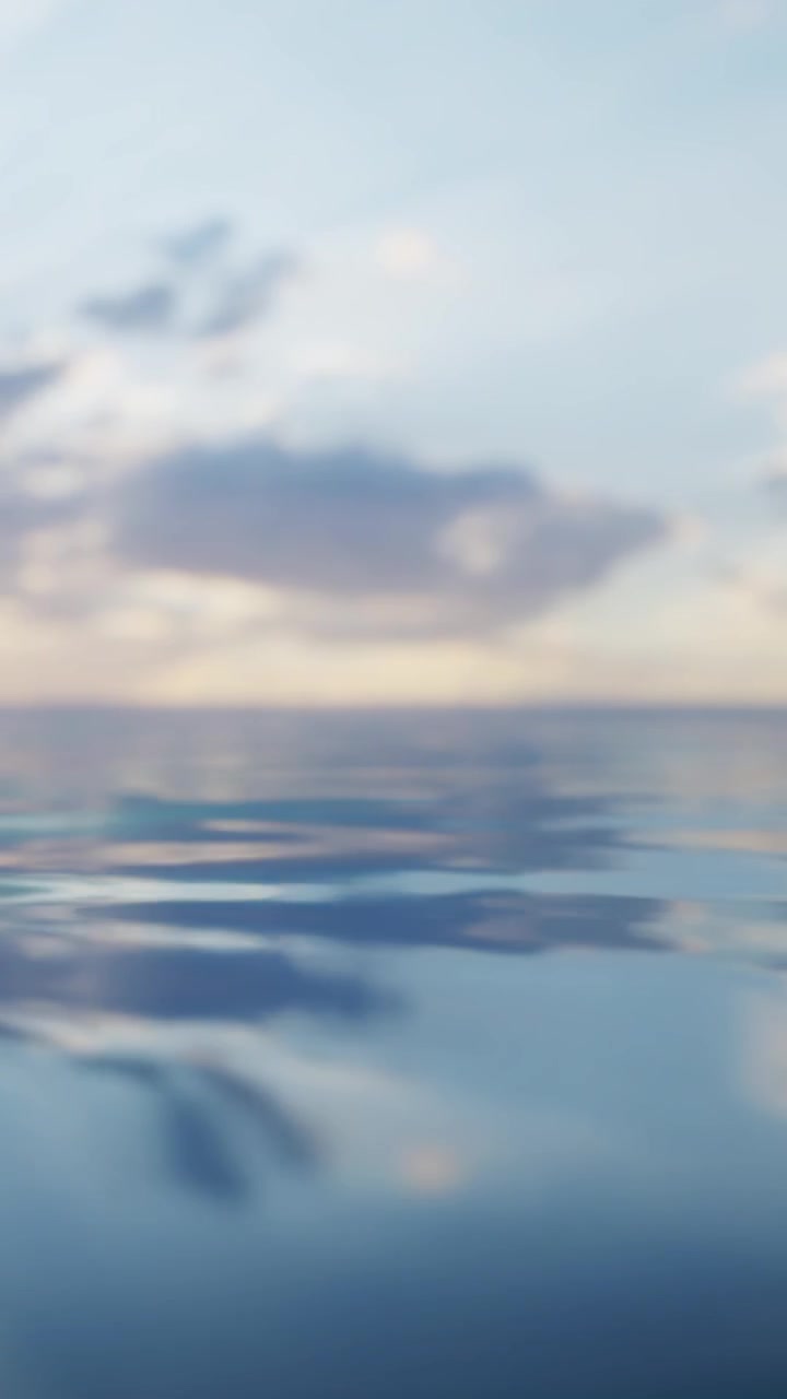 Calm water surface reflects sky with clouds during early morning hours