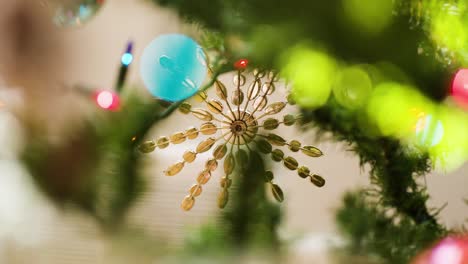 rack focus from lights to hanging star ornament on faux christmas tree, slow motion.
