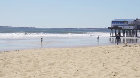 Woman-jogging-in-the-distant,-running-towards-Old-Orchard-pier-in-Maine,-faraway