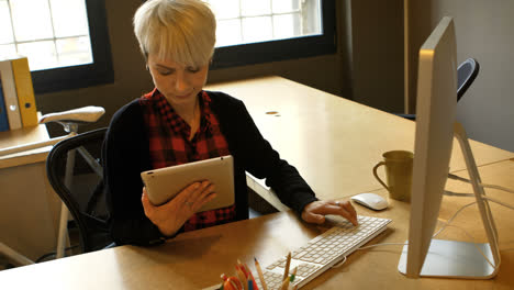 Female business executive using digital tablet and computer