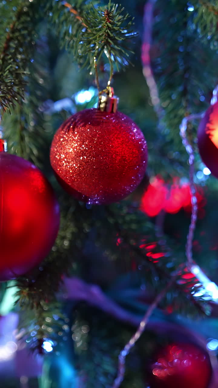 Christmas tree. Beautiful New year fir tree with bright Christmas balls and ribbons. Close-up. Festive atmosphere at winter holidays. Vertical video