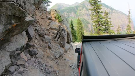 siguiendo un vehículo 4wd dando la vuelta a una curva de pasador de pelo en el sendero del oso negro en las montañas de san juan en colorado