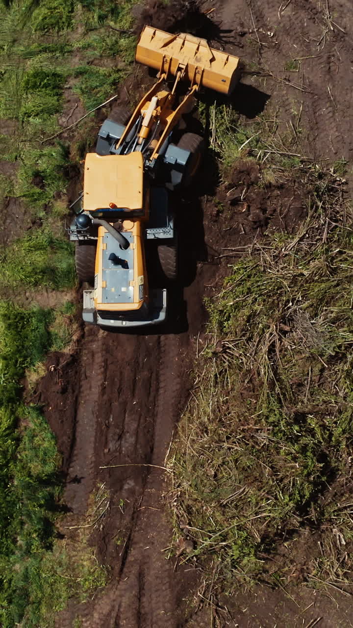 Bulldozer on countryside meadow. Top down view of bulldozer working on the field