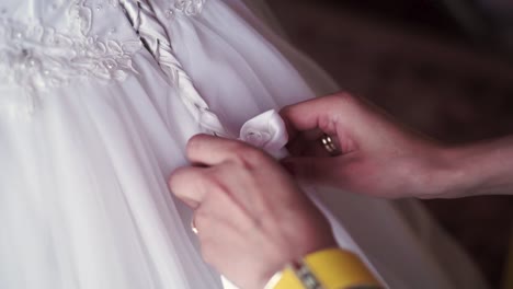 woman tying a ribbon on a wedding dress