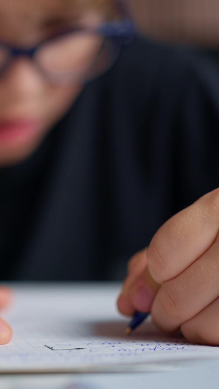 Primo piano della mano di un bambino che scrive su un quaderno
