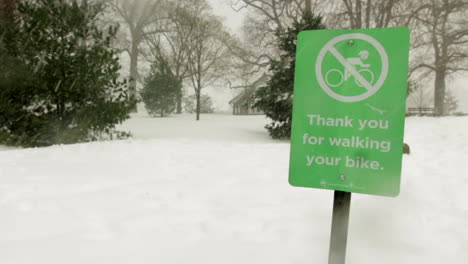 this is a shot of a sign getting covered in snow during a blizzard-snowstorm in prospect park in brooklyn, ny