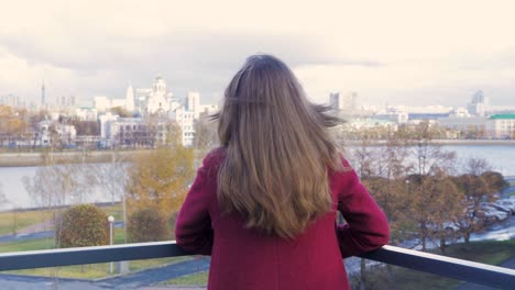 woman on balcony viewing cityscape