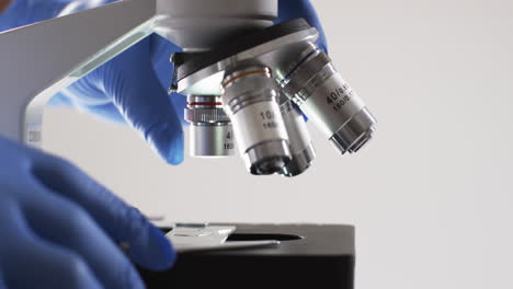 video of close up of scientist using laboratory microscope with copy space on white background