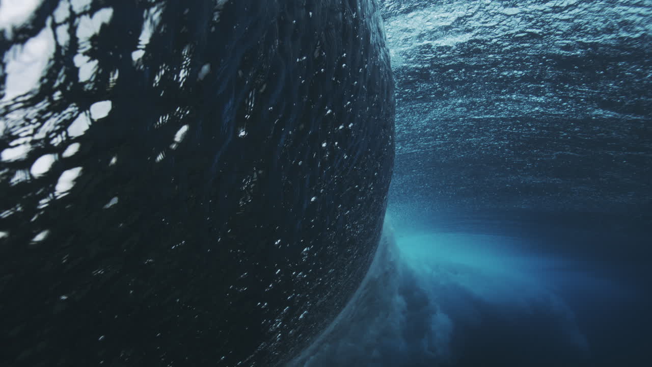 Powerful ocean wave separates itself from water as sparkling dazzling textured surface is broken in vortex