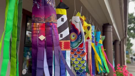 Colorful-wind-sock-with-fun-shapes-hanging-and-moving-in-the-breeze