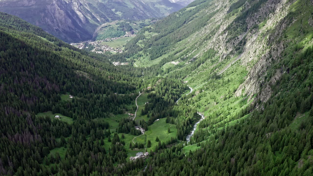 Scenic aerial view of lush green valleys and mountains near Cascate del Rutor waterfall