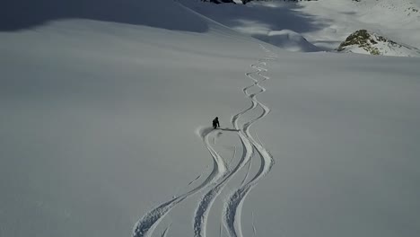 drone tracking skier going down empty powder slope