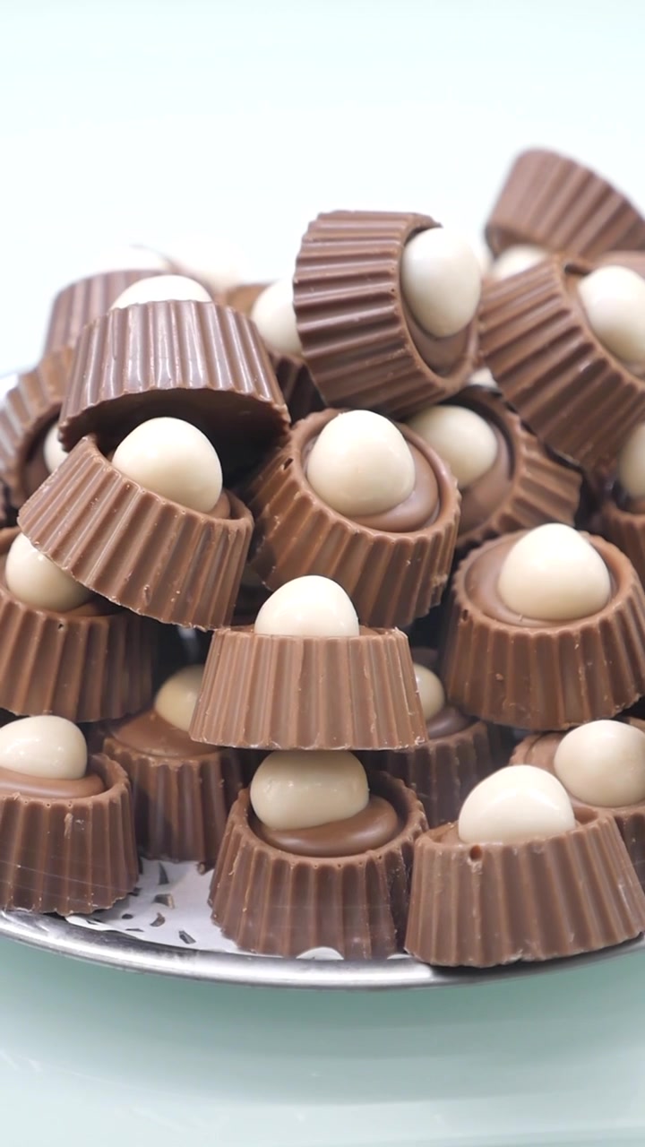 Pila di deliziose caramelle di cioccolato al latte con ripieno bianco