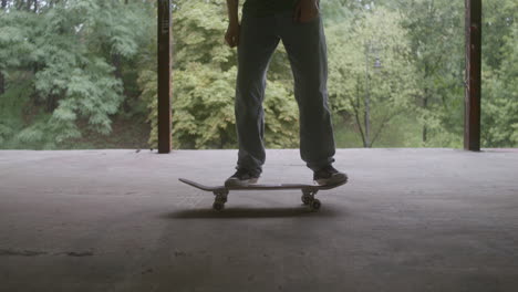 un ragazzo caucasico che fa skateboard in un edificio in rovina.