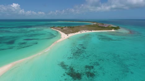 sahdes-of-blue-surrounding-tropical-island,-drone-shot-dolly-out-over-cayo-de-agua,-Los-Roques