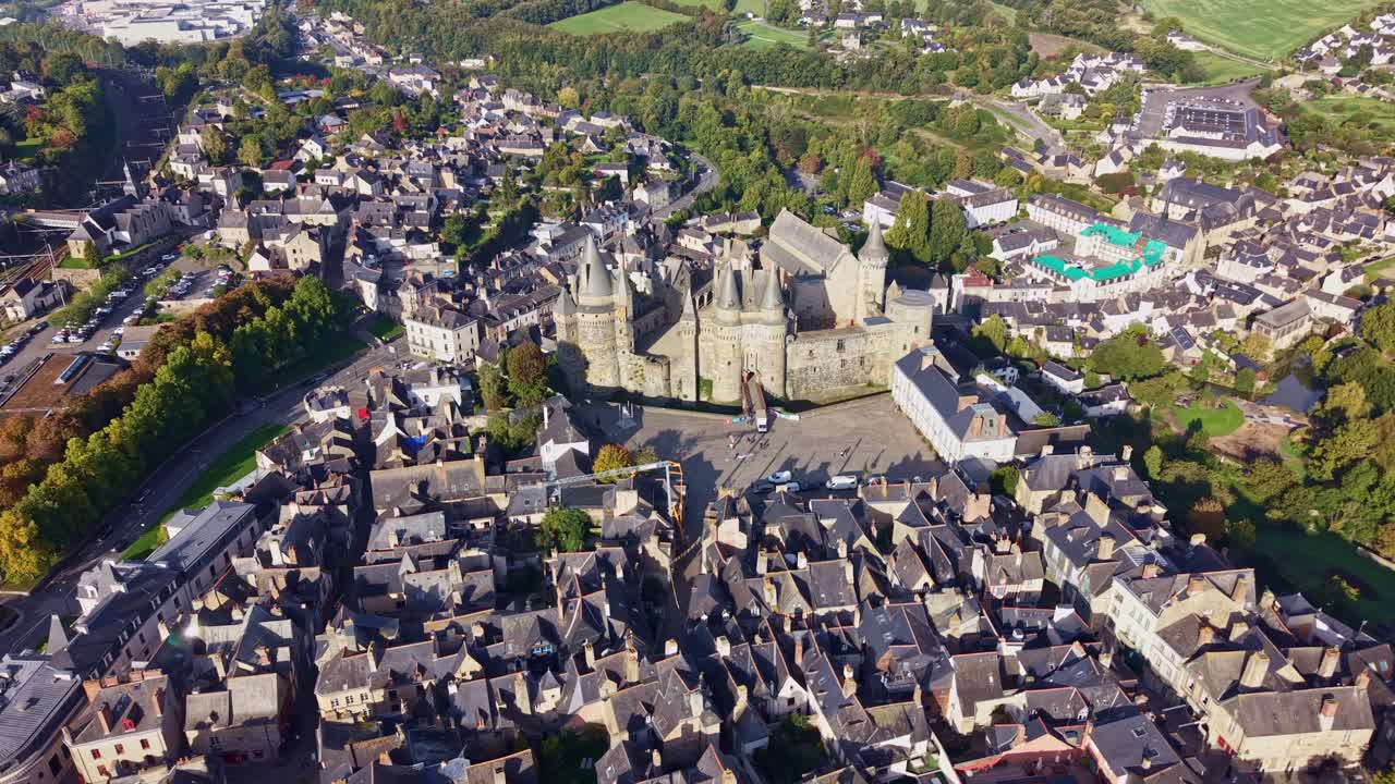 Aerial panoramic orbit of Vitre Castle in Brittany, France showing rooftops, stone walls, and city below