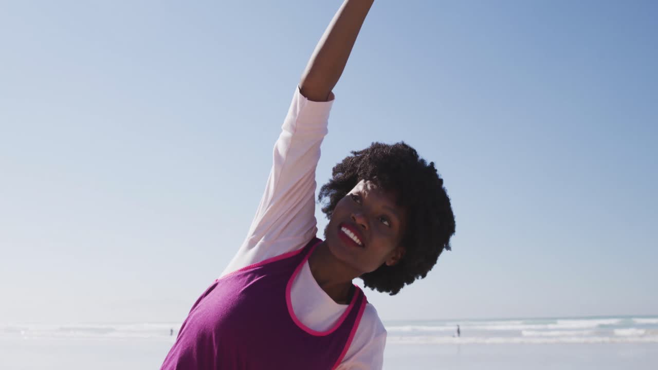 African American woman doing pyoga positon on the beach and blue sky background