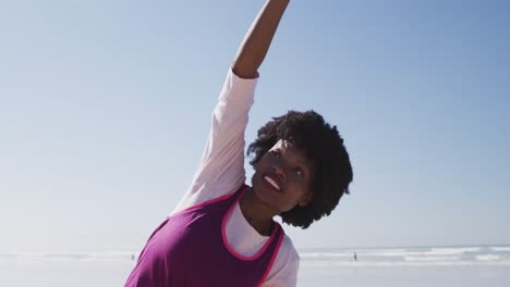 african american woman doing pyoga positon on the beach and blue sky background