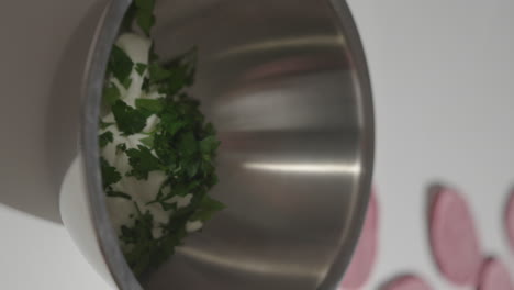 espolvorea perejil fresco en un tazón para mezclar con yogur