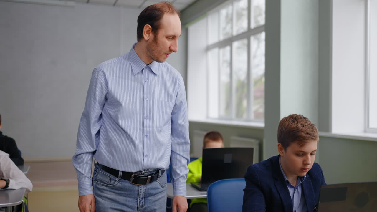 profesor interactuando con los estudiantes en una clase de computadora