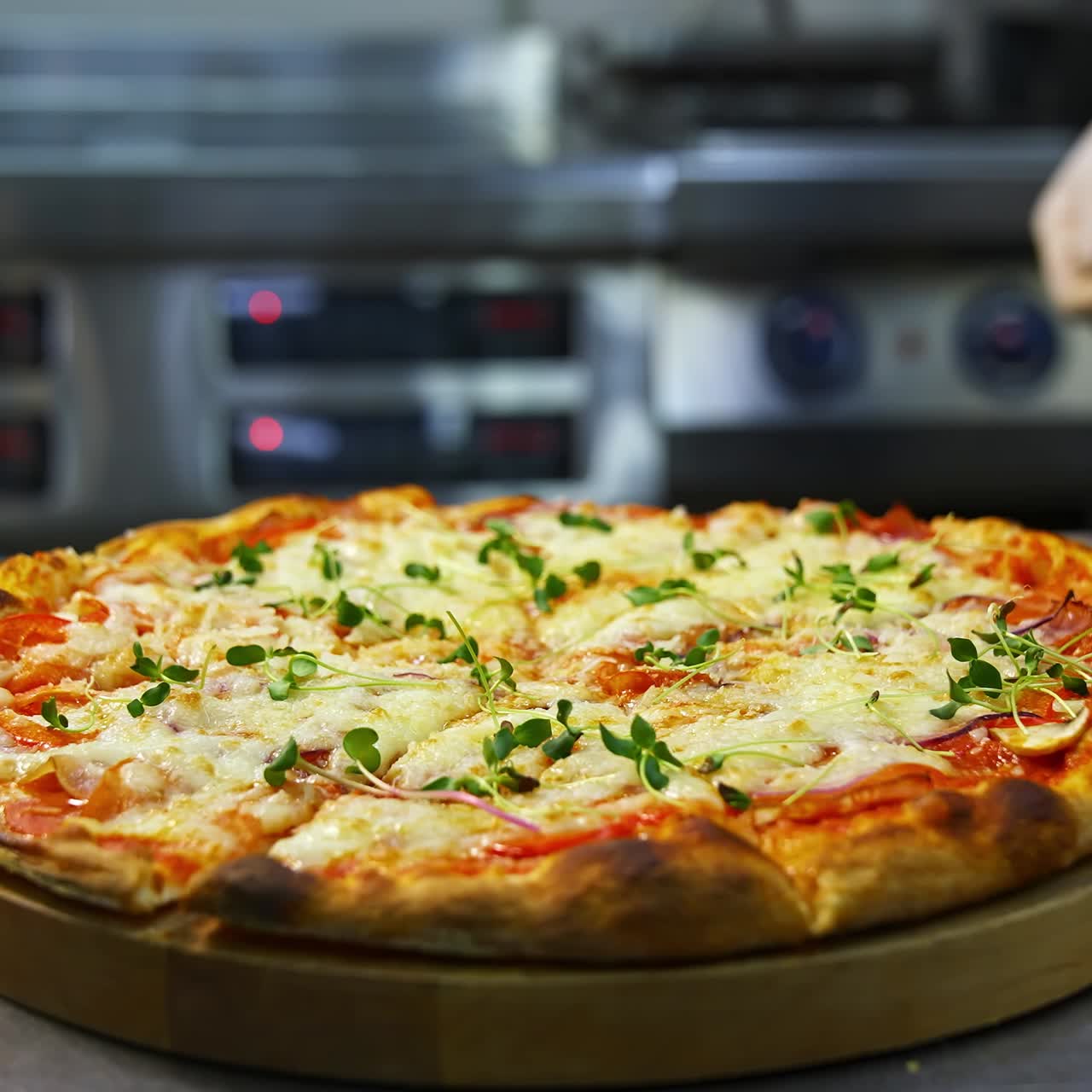 Delicious pizza on wooden board. Hands in gloves taking one piece of ready pizza. Well-baked pizza with melted cheese in the restaurant
