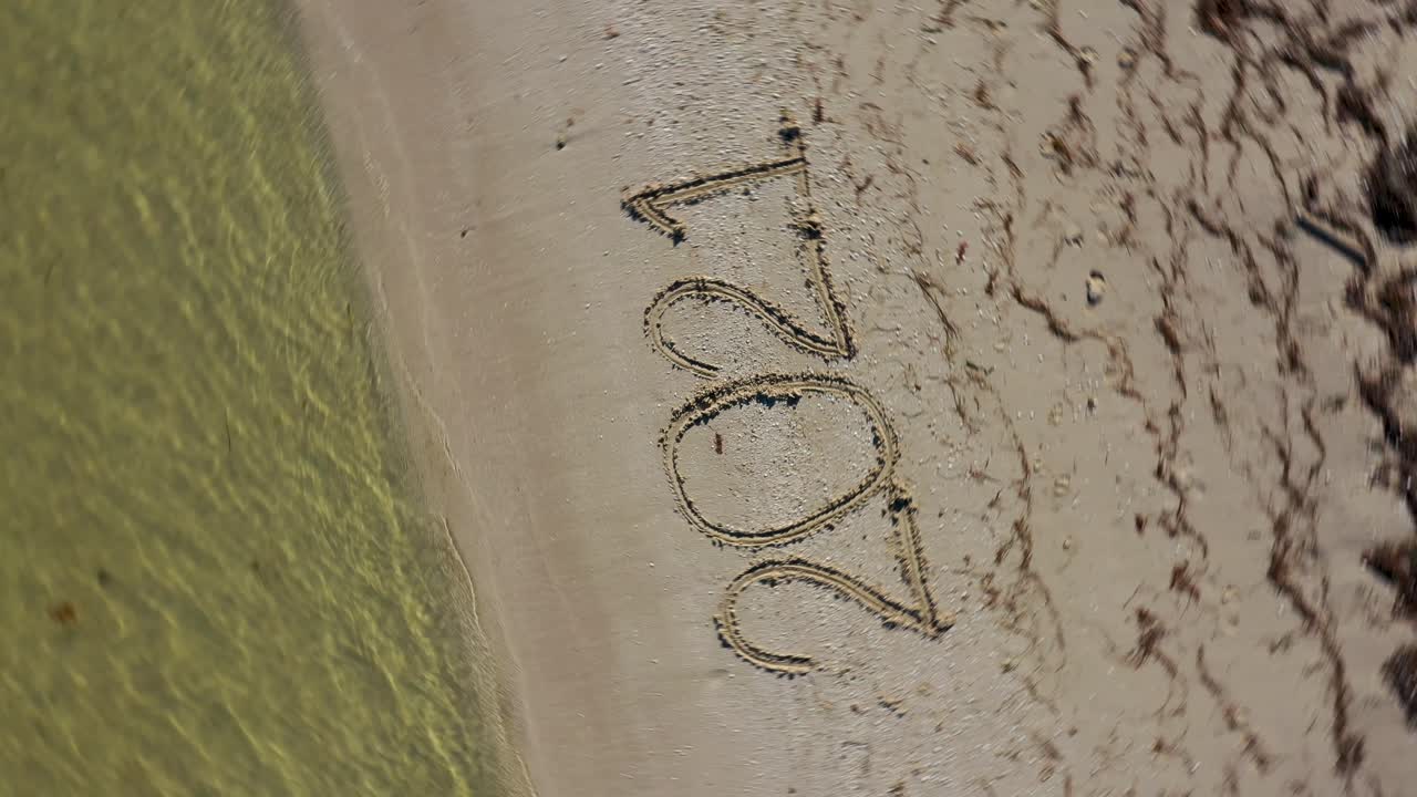 Twenty Twenty One written in the sand and spinning clockwise continuously showing it as a crazy year