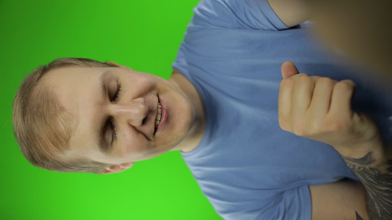 disparo vertical de mano de un joven haciendo una selfie, llamada de video. llave de croma