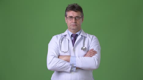 hombre maduro y guapo médico contra fondo verde
