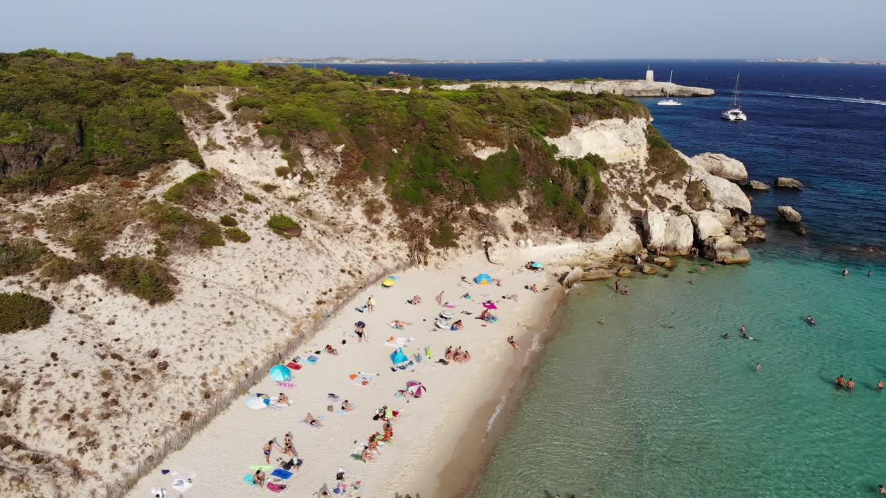드론은 화창한 오후에 코르시카 섬의 그란데 스페론 해변에서 뒤로 날아갑니다.