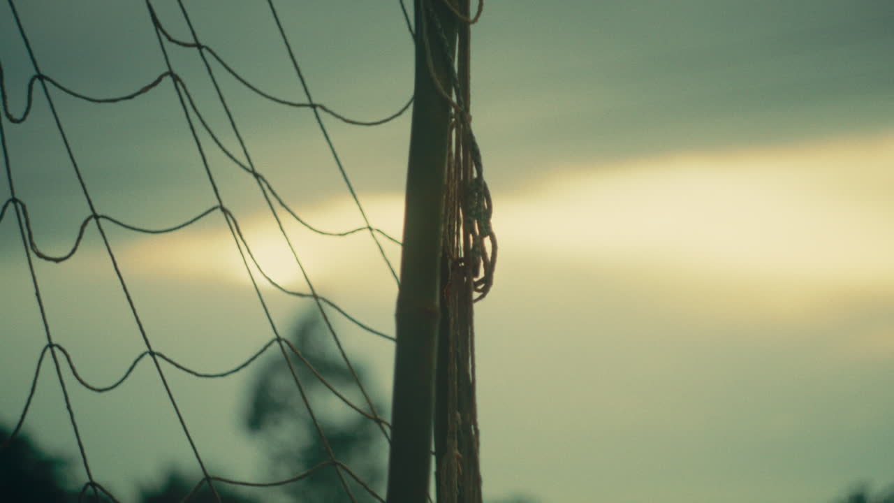 Football net, close-up view with soft light in the background, outdoors, sunset ambiance