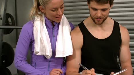 muscular man discussing with female athlete