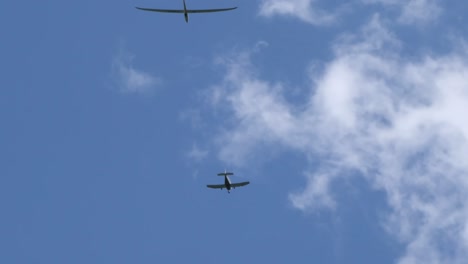 motor plane and glider plane spotted flying in the sky on clear bright day