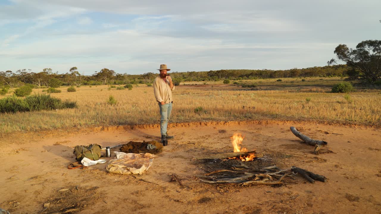 오스트레일리아 의 외 지역 에서 캠프 불  에서 파이프 를 피우고 있는 스와그맨