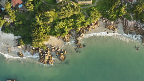 heavenly rocky brazilian beach coastline top down view at sunset, jurere internacional, florianopolis, santa catarina, brazil