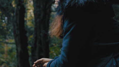 young woman standing on wooden bridge in forest looking pensive enjoying nature exploring natural outdoors