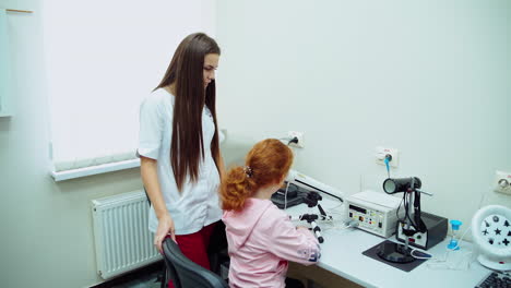 small girl visiting ophthalmologist. female ophthalmologist checking eye of small child
