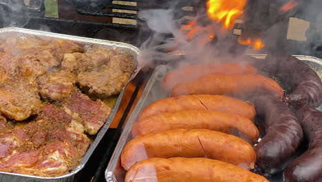 marinated pieces of meat and german sausages grilled on bbq grill at the yard in poland daytime