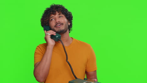 young indian man talking on wired vintage telephone of 80s says hey you call me back conversation