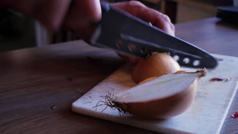 Primer-Plano-De-Mano-De-Un-Anciano-Cortando-Algunas-Cebollas-En-Una-Tabla-De-Cortar-Blanca-Con-Un-Cuchillo-Afilado-Y-Las-Recoge-Para-Un-Plato-Cajún