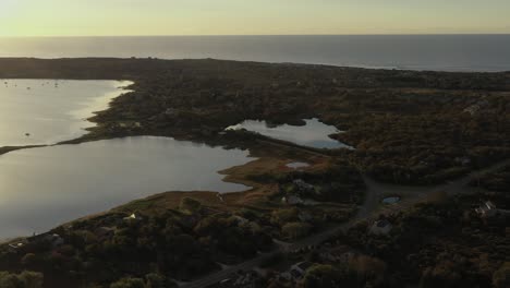 aerial trucking shot across montauk lake and the atlantic ocean at the end of long island new york at sunrise