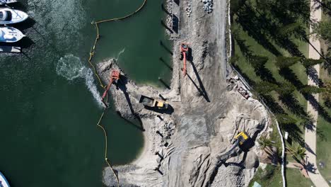 large construction machinery working on a coastal project to develop a new boating marina and harbor