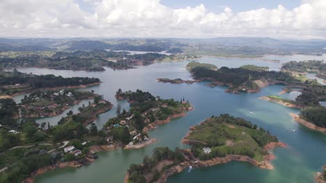 El-peñón-de-guatapé-lake-with-lush-green-islands-and-surrounding-mountains,-aerial-view