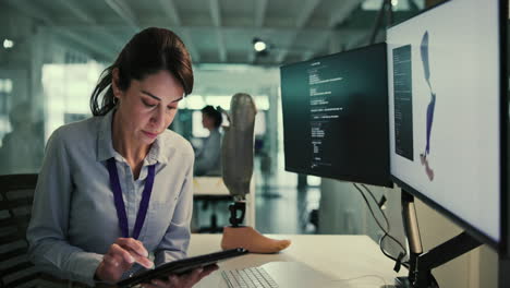 una mujer trabaja en una computadora en su escritorio en una oficina